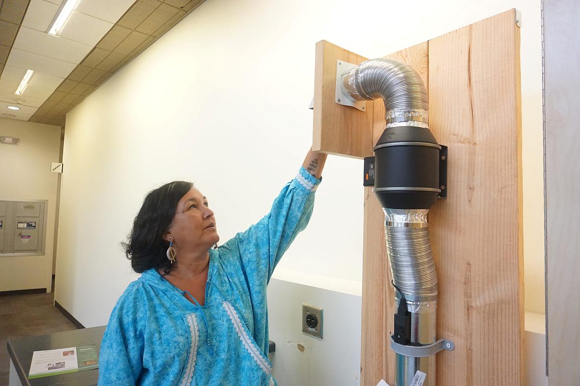 Jackie Qatalina Schaeffer, of the Alaska Native Tribal Health Consortium, explains the workings of a Mini-PASS in-home sanitation system. Jackie Qatalina Schaeffer, of the Alaska Native Tribal Health Consortium, explains the workings of a Mini-PASS in-home sanitatio