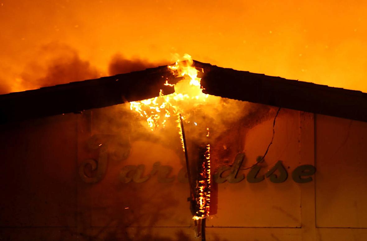 A sign is posted on the Paradise Skilled Nursing Center as it is consumed by flames from the Camp Fire on November 8, 2018. (Jus