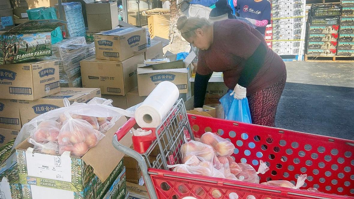 A volunteer packages peaches during a food distribution at Vida Life Ministries in Bloomington on July 16, 2022.