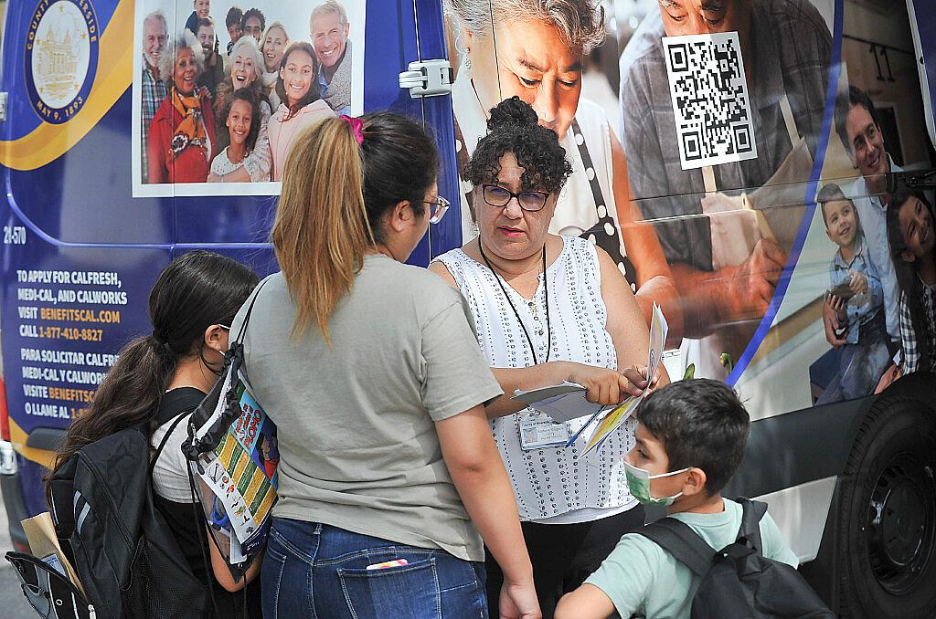 Riverside County Department of Public Social Services employee, Adriana Magana, talks with Diana Hernandez of Riverside regarding Calfresh benefits during a community health fair at Arlanza Elementary in Riverside, Ca., July 30, 2022. Riverside County Department of Public Social Services employee, Adriana Magana, talks with Diana Hernandez of Riverside regardin