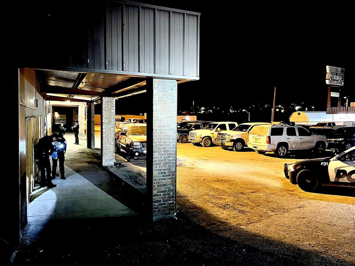 Public safety officers help an intoxicated man who had fallen asleep outside the Sports Page Lounge in Gallup, N.M.