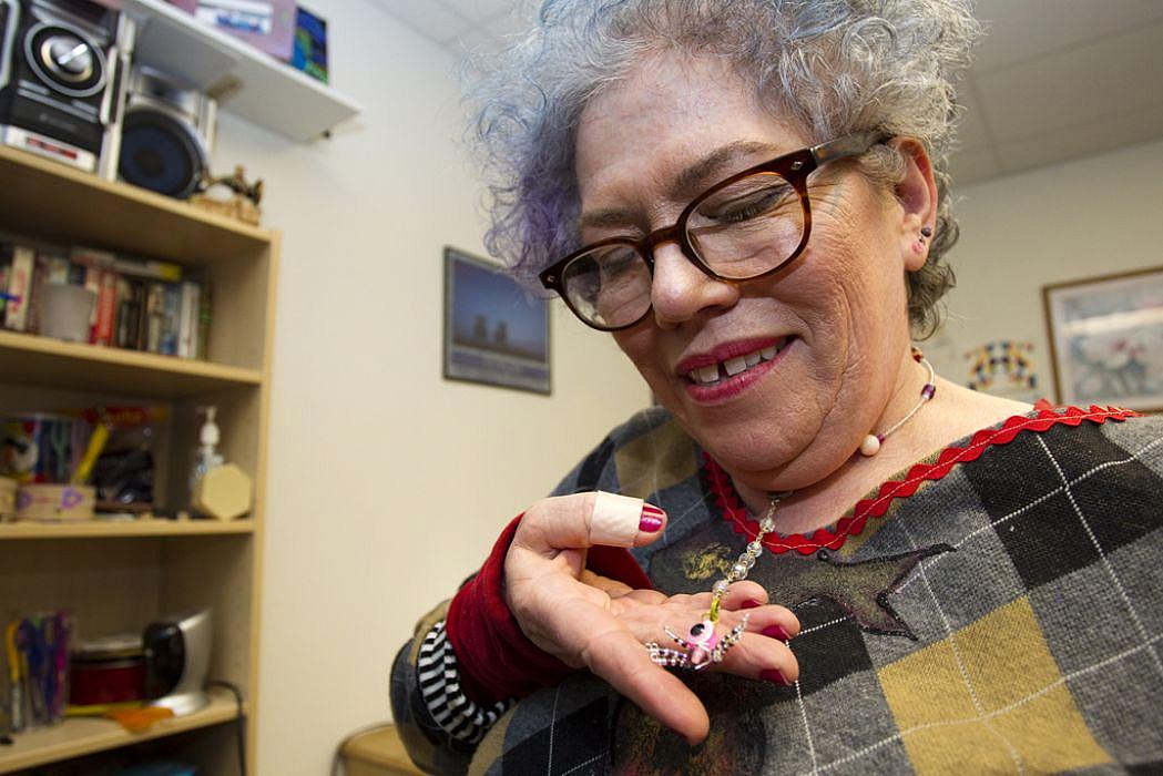 Rita Daley shows off a necklace she made: “The world views me as insane,” she said. At the center, “instead of calling me crazy,