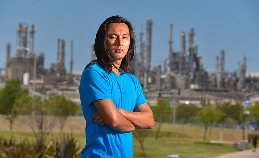 With the ConocoPhillps refinery behind him, Nick Serrano stands in the Wilmington Waterfront Park in Wilmington on Friday, Aug. 