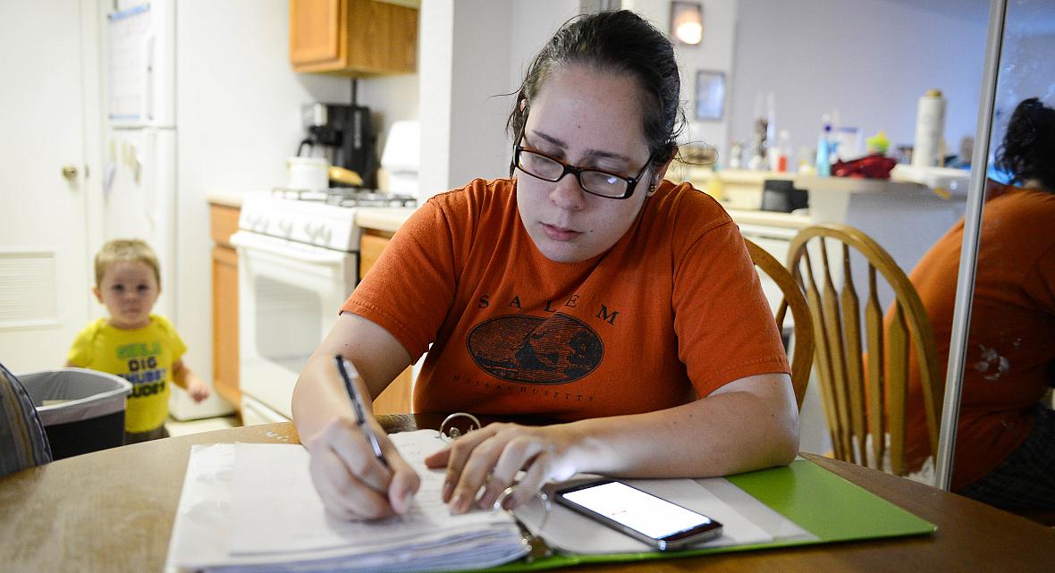 Jennifer tries to pay bills and go through some paperwork while her son, David, 2, competes for her attention. STAFF PHOTO / RACHEL S. O'HARA