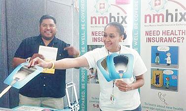 Antwhan Yazzie, left, and Monica Marthell, staffers for the Native American Professional Parent Resources (NAPPR) in Albuquerque, N.M., hand out fans at an outreach booth. Both were working a public event to generate awareness for the Affordable Care Act. (Photo courtesy of NAPPR)