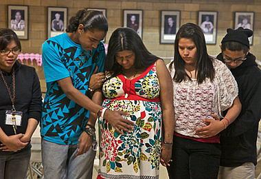 Candida KingBird bows her head in prayer during her baby shower two weeks before her daughter's birth.