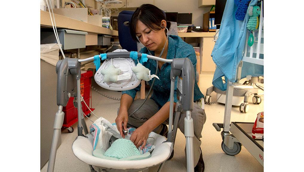 Dr. Lily Martorell-Bendezu checks an opiate-addicted baby’s heart and muscle tone in the neonatal intensive care unit at Riversi