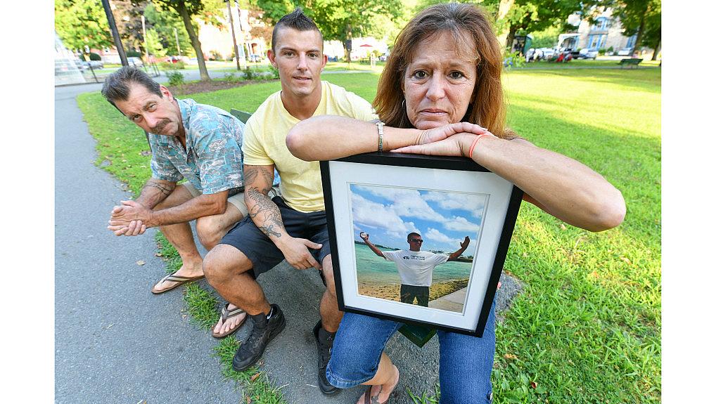 Lynne Russell, of Hawley Pa., holds a photo of her late son, Patrick, on July 25, 2019, as she sits with her husband Patrick.