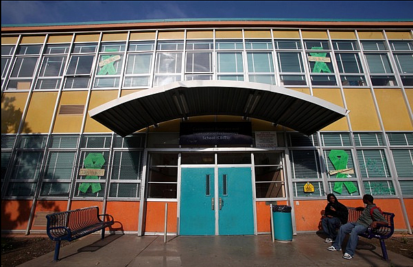 Students sit in front of Castlemont Business Information Technology School in Oakland, Calif.