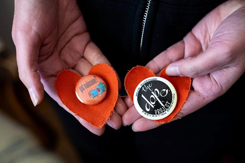Rachel McLean holds two pins on orange fabric hearts from the memorial for Pete Morse, at her home on March 10, 2022.