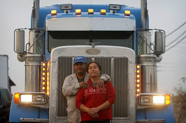 Jose Rodriguez and his wife, Maria, with their truck near their home in Jurupa Valley. The family makes a living moving goods around the nation.