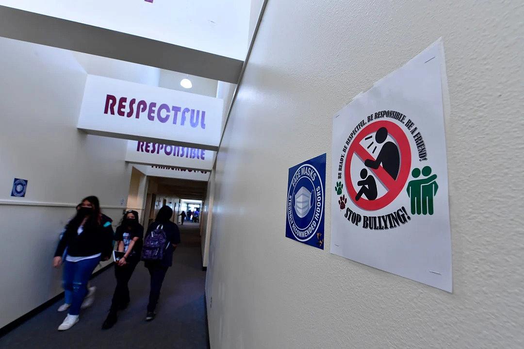 Students walk past one of the many anti-bullying signs posted around Harry S. Truman Middle School in Fontana on Thursday, March