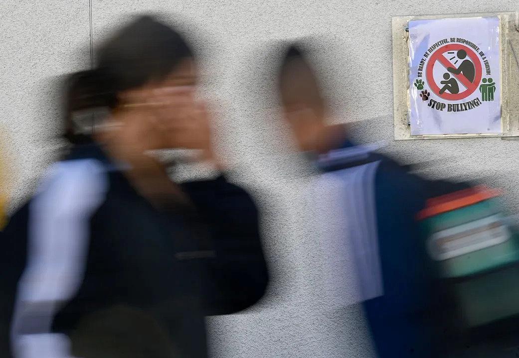 Students walk past one of the many anti-bullying signs posted around Harry S. Truman Middle School in Fontana on Thursday, March