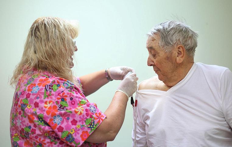 Ray Ingram, 86, gets help with shock therapy from clinic employee Kelly Dority at Helton Rural Health Clinic in Coalgate, Okla. 