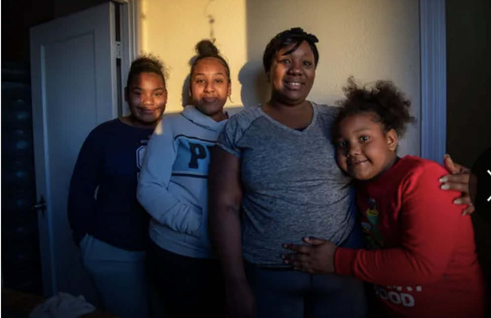 Tanya Harris and her daughters stand inside their restroom for a portrait on Feb 04