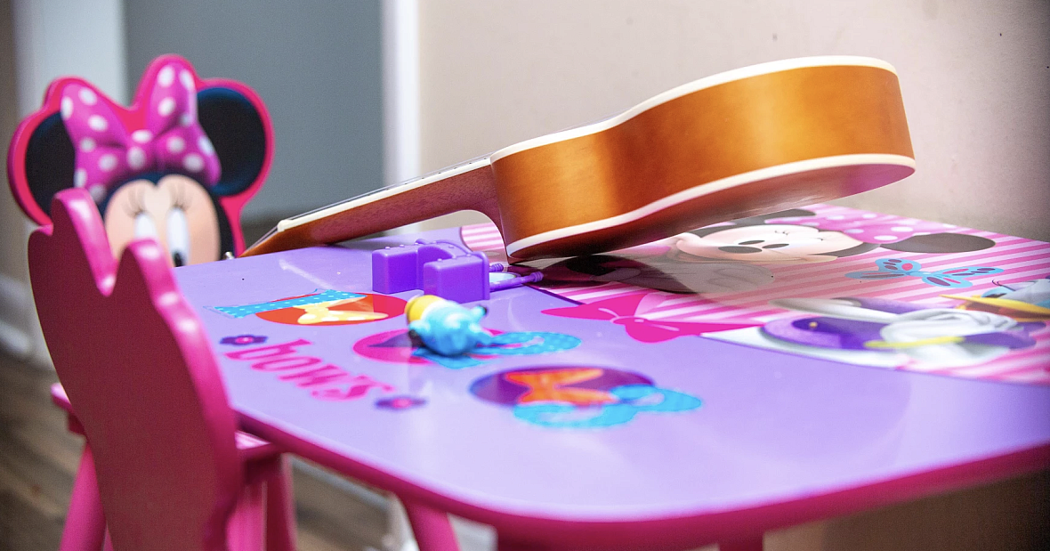 Nadia's Minnie mouse play table, with a small guitar on it.