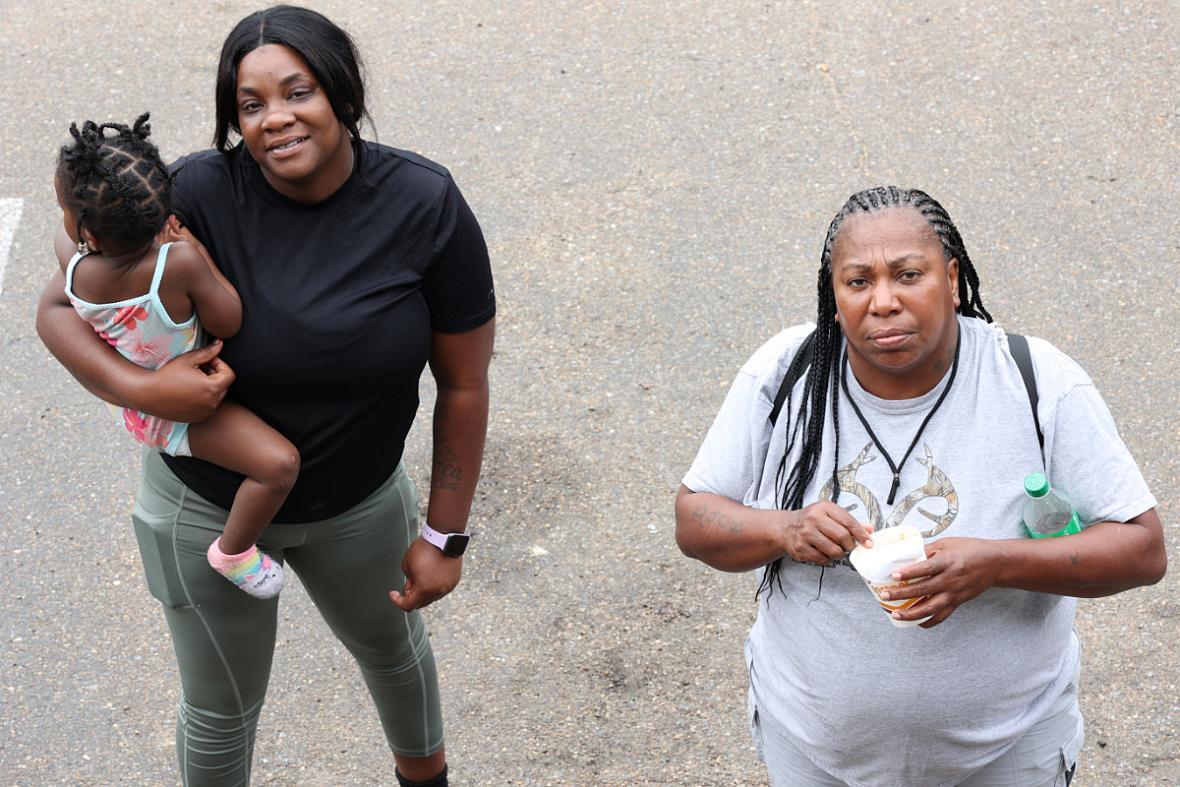 Jasmine Sandifer, left, whose mother is a resident at Sunset Village, and Doris Williams, right, wait outside their motel rooms 