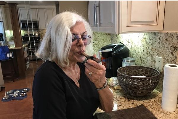 Linda Tisbo, a member of the Laguna Woods Medical Cannabis Collective, cleans out her pipe on April 11, 2018. 