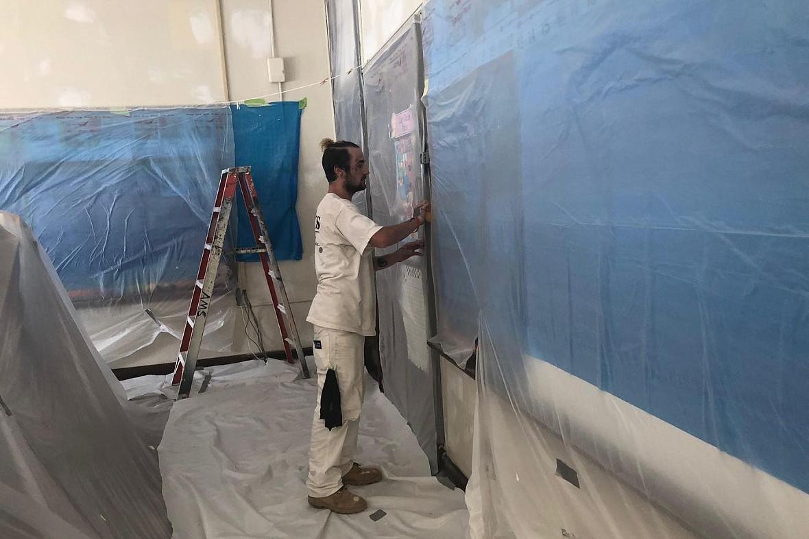 A worker performs lead paint and plaster stabilization at Clara Barton Elementary School.