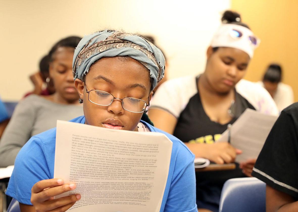 Cailah Porter, 15, reads over an example of a short story as she and fellow Upward Bound students prepare to work in groups to c