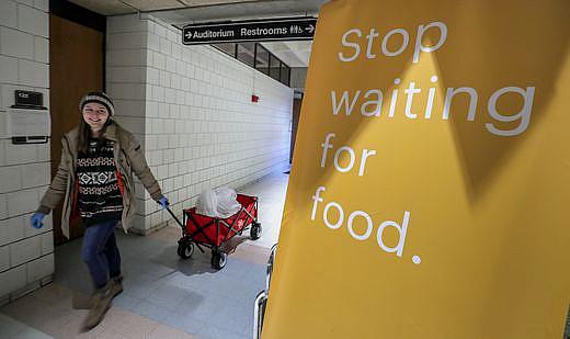 Henny Ransdell pulls a wagon carrying Einstein Bros. Bagels in the Bingham Humanities Building on UofL's campus. The bagels, don