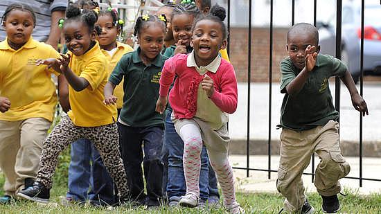 Students at Little Flowers Child Development Center laugh and play during a morning on the playground. Some of the children who attend the Baltimore school are exposed to violence in their neighborhood - an exposure scientists increasingly realize can cause health impacts. (Lloyd Fox, Baltimore Sun)