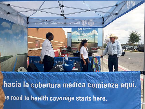 Insurance agents working with Blue Cross Blue Shield of Texas answered questions outside of a Target in San Antonio from potential customers on Dec. 12, 2014. Veronica Zaragovia/KUT