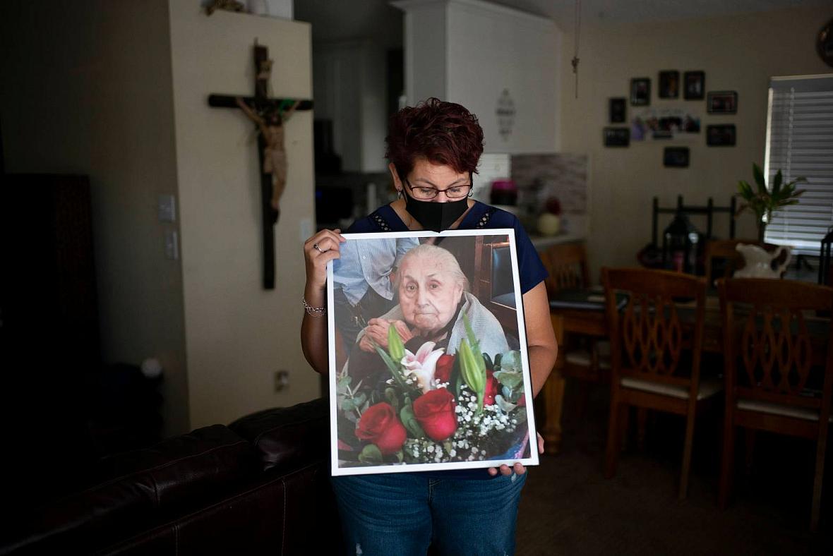 Marisela Munoz holds a photo of her aunt, Evangelina C. Martinez, who raised her since birth, at her home in Canyon Country, Fri