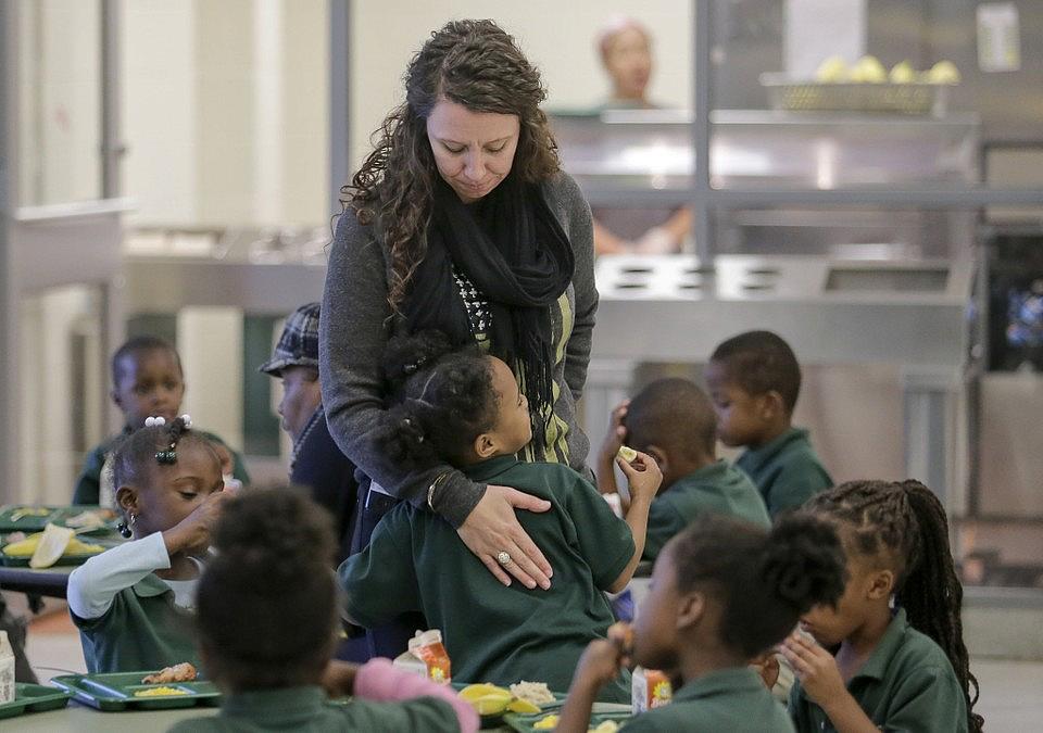 Lawrence D. Crocker College Prep counselor Rochelle Gauthier gets a hug from a student during lunch at the school in New Orleans