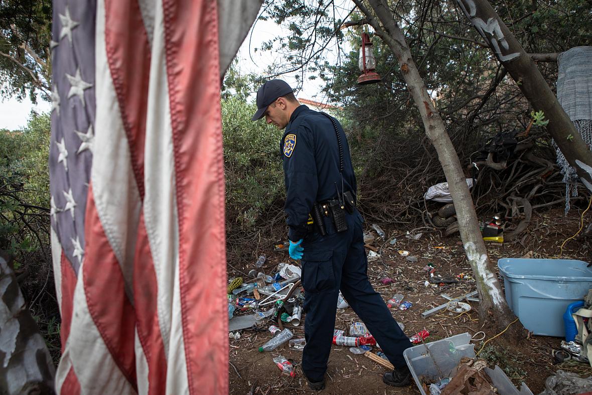 California Highway Patrol Officer Jesse Matias looks for an individual he has previously interacted with that suffers from mental illness in an encampment near a freeway in San Diego, April 28, 2022. Like other law enforcement agencies, the Highway Patrol responds to mental health crisis calls and may transport individuals to hospitals for possible involuntary holds if an officer determines they meet criteria. California Highway Patrol Officer Jesse Matias looks for an individual he has previously interacted with that suffers from menta