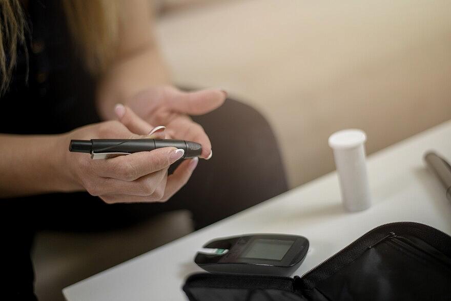 Diabetic young women performing a glucose level blood test at home