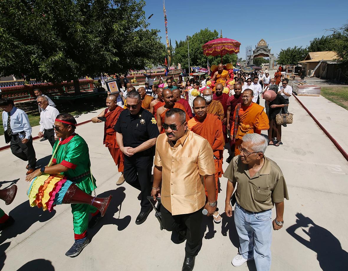 Danny Kim walks a parade for the Temple Abbot, Say Bunthon during the Holy Water Blessing ceremony at the Fresno Cambodian Buddh