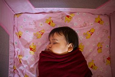 A 10-month-old girl takes a nap in the child development center.