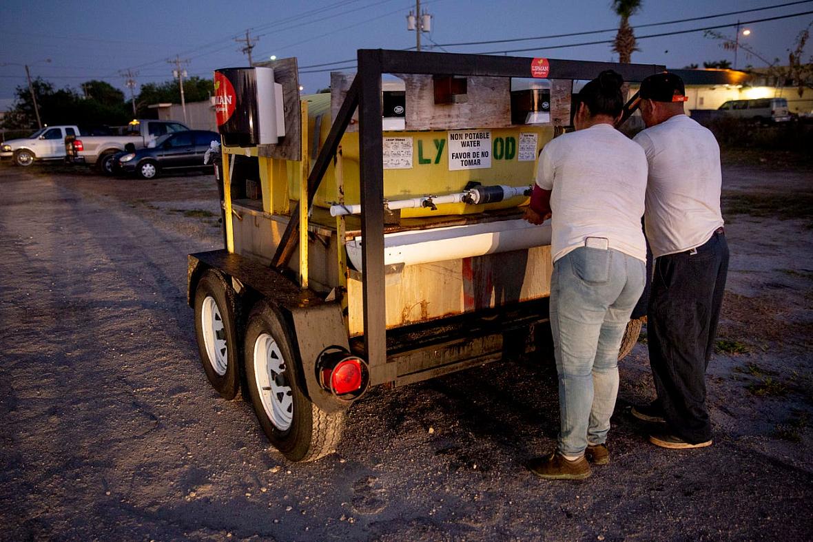 Norma Caldon, left, and Inocente Ordoñez, right, wash their hands before getting on a bus to work in Immokalee on Friday, April 