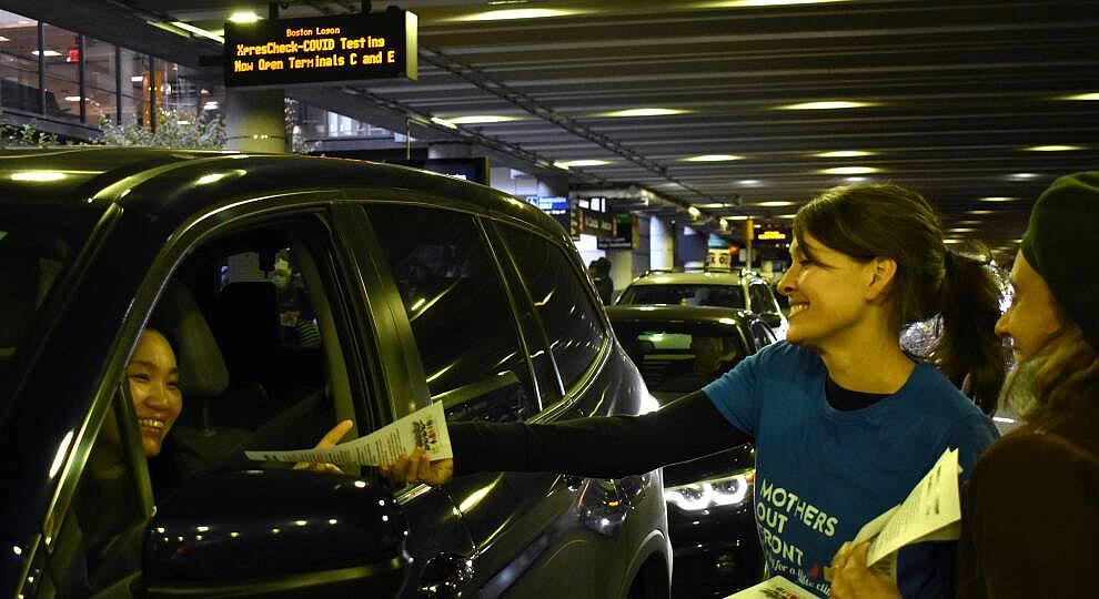Sonja Tengblad hands an information sheet to a driver idling outside of Logan Airport’s Terminal B.
