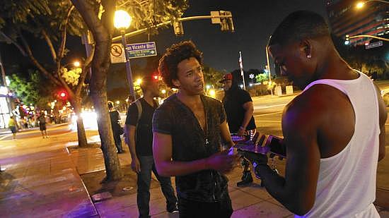 Thomas Davis spends a night in September asking people in West Hollywood to participate in a UCLA study about mobile apps and their ability to help improve health and combat disease. (Michael Robinson Chávez)