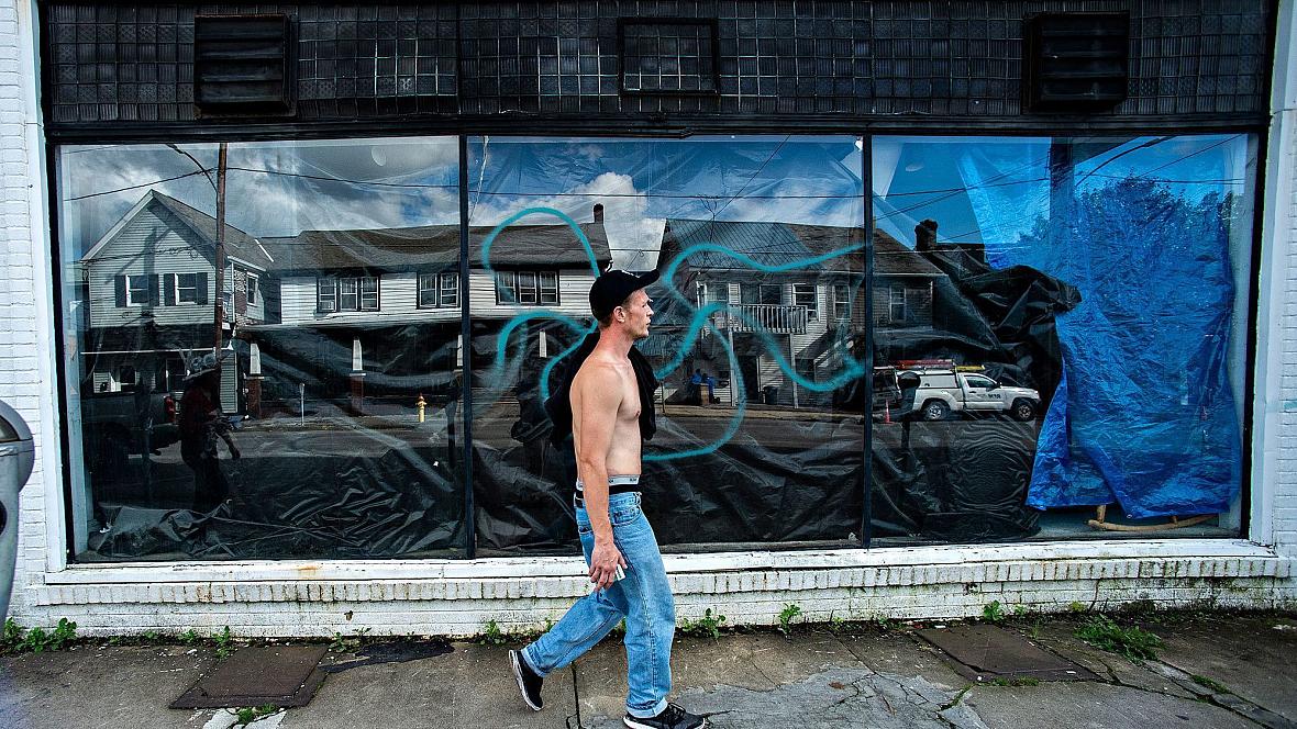 Travis Litts walks past an abandoned business along East Ridge Street in Lansford. He is one of Pennsylvania's many rural reside