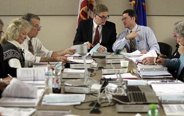 Dr. Sheldon Wasserman, center, chairman of the Wisconsin Medical Examining Board, talks with Tom Ryan, right, executive director of the board. On the left are board members Jude Genereaux and Dr. Gene Musser. The 13-member board, appointed by the governor, includes 10 doctors and three public members.  