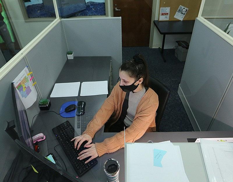 Brittany Irby, a state child abuse hotline operator, works on abuse reports at her workstation 