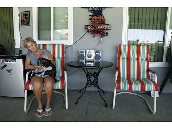 Mary Buffum, 65, of Fontana sits with her dog, Cash, next to her late husband Jack's chair on the patio where they loved to entertain family and friends. Jack Buffum, 59, was killed May 30, 2013, in a workplace accident in Rialto.