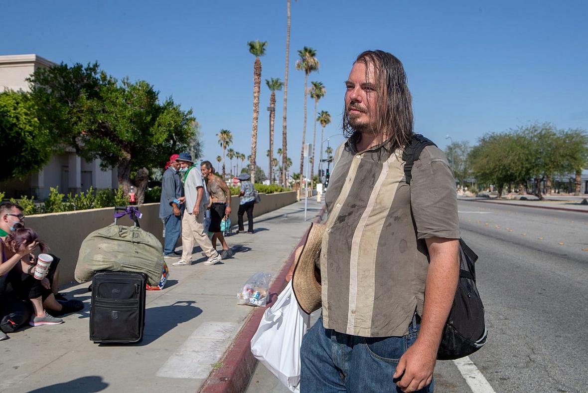 Janos Szilagyi, 39, right, waits across the street before the emergency overnight shelter run by the Coachella Valley Rescue M