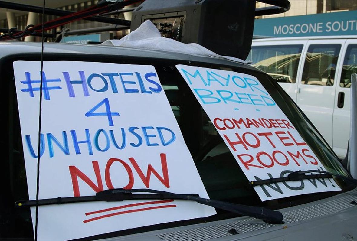 In this April 3, 2020, file photo, activists protest from vehicles outside Moscone Center, asking San Francisco Mayor London Breed to house homeless people using vacant hotels in San Francisco. San Francisco's mayor reported Friday, April 10, 2020, that 70 people at the city's largest homeless shelter have tested positive for COVID-19, infuriating advocates of the homeless who have been pushing the city for weeks to get people out of crowded shelters and into individual hotel rooms. In this April 3, 2020, file photo, activists protest from vehicles outside Moscone Center, asking San Francisco Mayor London Bre