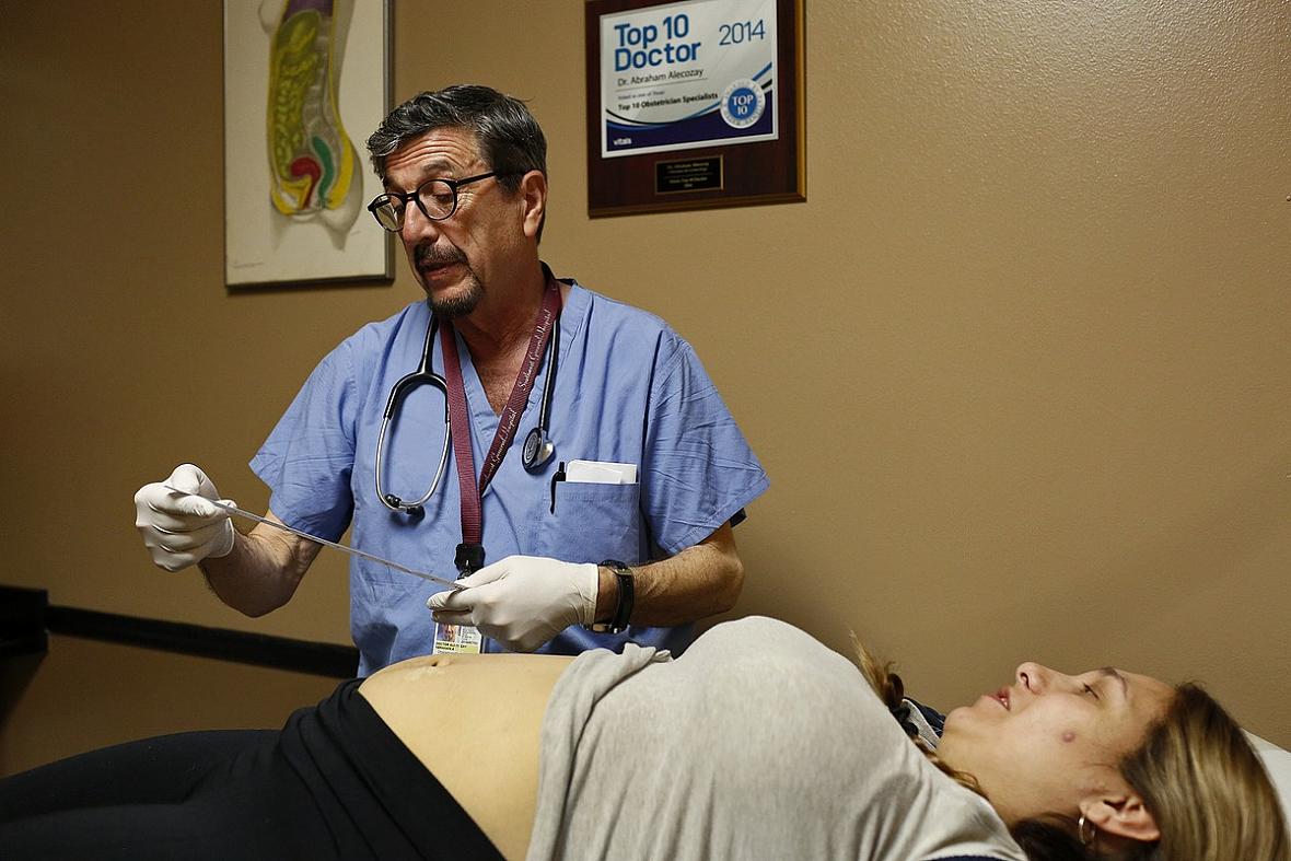 Dr. Abraham Alecozay, an OB/GYN, measures the growing stomach of Zully Torres during her exam at his office. Health-care providers track the growth of a fetus during pregnancy, one of the reasons experts recommend pregnant women receive early and consistent prenatal care throughout their pregnancies.