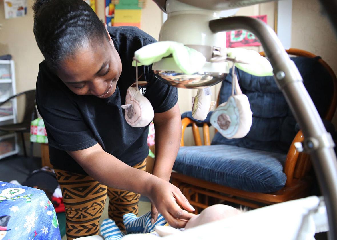 Andrea Daniels, of Fort Wayne, tends to a child last month at the day care where she works.
