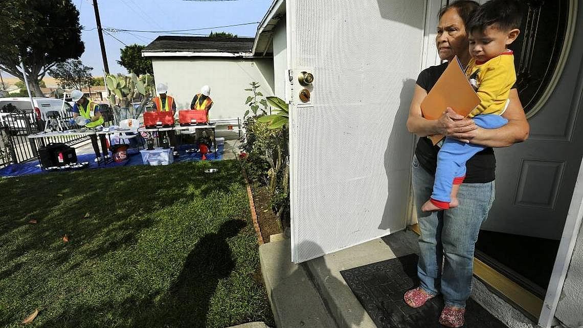 Otilia Franco and her grandson Noe Avina, 2, stand in front of their home in Commerce in February 2016. The Los Angeles County Health Department tested the soil for possible lead contamination from a nearby closed Exide battery plant. Mel Melcon Los Angeles Times/TNS Mel Melcon Los Angeles Times/TNS