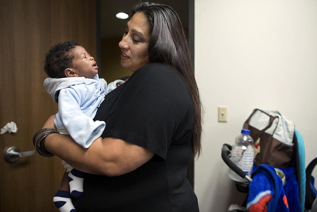 Health educator Cecie Trujillo holds 2-month-old Tray'von Lynn, son of class attendee Tamika Rosser. Inglewood-based Great Beginnings for Black Babies aims to reduce infant mortality through support like this class. Maya Sugarman/KPCC Maya Sugarman/KPCC