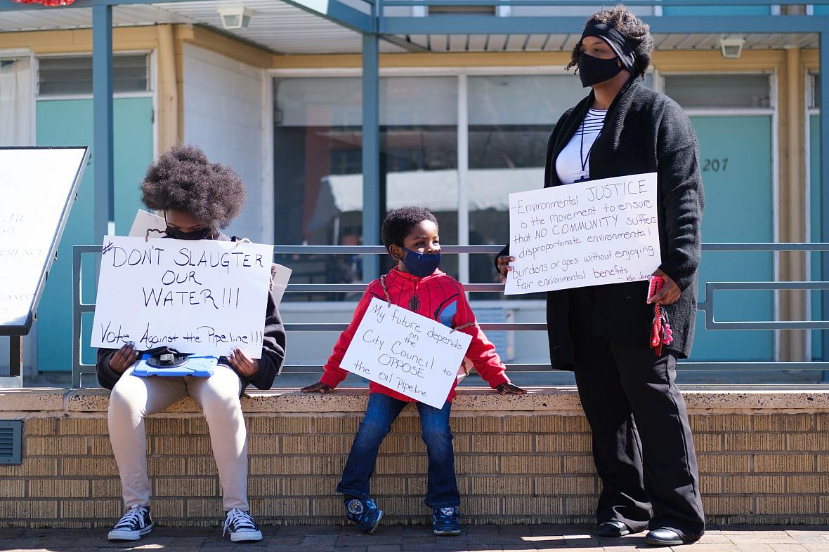 Kizzy Jones, a co-founder of Memphis Community Against the Pipeline (MCAP), hold signs outside the National Civil Rights Museum 