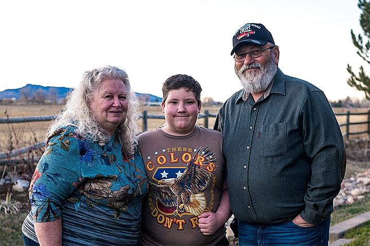 Child standing between Grandparents