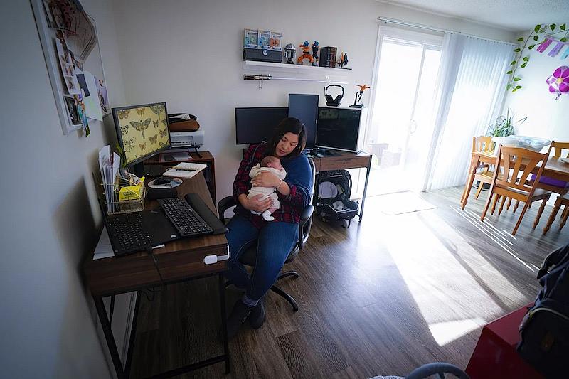 Zaira Reynoso juggles caring for her 2-week-old baby, Ander, and checking email at her home in Chula Vista. Reynoso, who works from home as a coach to family child care providers, spends a lot of the day in online meetings and answering emails, and because of the cost of day care, she is caring for her newborn while she works.(Nelvin C. Cepeda / The San Diego Union-Tribune) Zaira Reynoso juggles caring for her 2-week-old baby, Ander, and checking email at her home in Chula Vista.