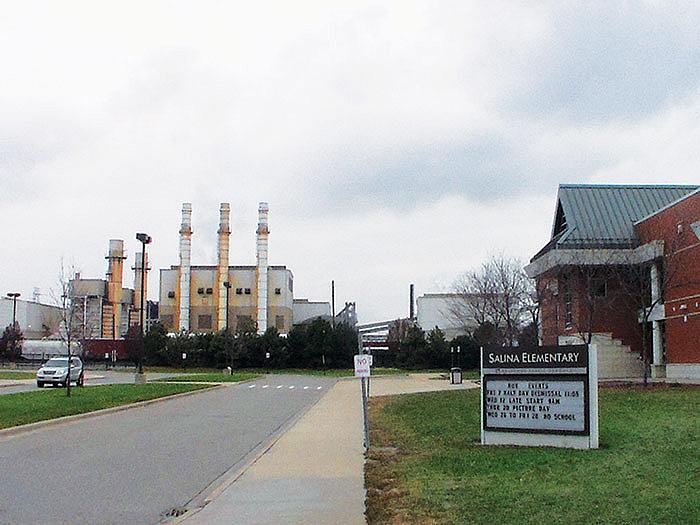 A fence separates Salina Elementary School in Dearborn's southend from industrial sources, including the former Severstal plant that is pictured here right across from the school. (Photo by Arab American News)